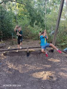 Photo of a Beaver and a Cub swinging on ropes in the assault course at Paddicks Patch